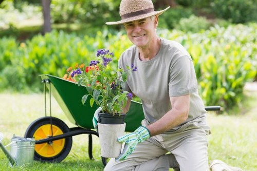 Gardener applying finishing touches to a planted bed in Canary Wharf